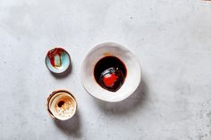 two small bowls filled with liquid on top of a white countertop next to each other