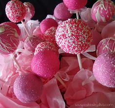 pink and white cake pops with sprinkles on them