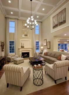 a living room with couches, chairs and a fire place in the middle of it