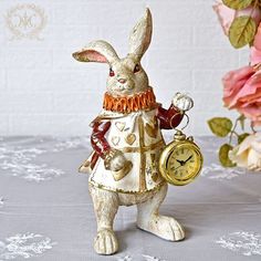 a white rabbit figurine holding a clock