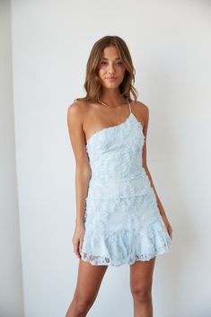 This Item is excluded from promotions. Hey babe, meet the mini dress of your dreams! The Livia One Shoulder Lace Ruffle Mini Dress is the perfect white party dress. Featuring an asymmetrical neckline with an adjustable spaghetti strap, ruffle hem, and subtle polka dots. Available in white and blue. Complete the fab look with the Ukari Clear Block Heel. Details 100% Polyester Fully lined Hidden back zip closure Material has minimal stretch Hand wash / Hang dry Blue Recruitment Dresses, Winfo Dresses Short, Blue And White Mini Dress, Spring Rush Outfits, Short Birthday Dresses, Homecoming Short Dresses, Spring Fling Dresses, Light Blue Dress Short, Sorority Recruitment Dresses