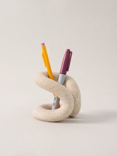 two pencils are in the middle of a sculpture made out of concrete and plastic