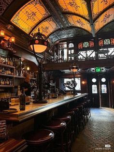 the interior of a bar with stained glass windows