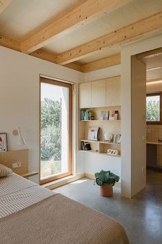 a bed sitting in a bedroom next to a window with open shelves on each side