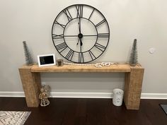 there is a clock on the wall next to a small table with a tabletop