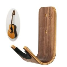 a wooden guitar hanger with a black strap and a brown ukulele hanging from it's side