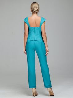 a woman in a blue jumpsuit with her back to the camera, looking down