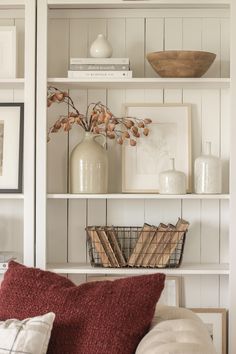 a white bookcase with books and pictures on it, along with other decorative items