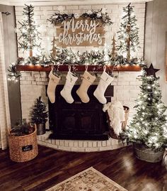 christmas stockings hung on the mantle in front of a fireplace decorated with greenery and lights