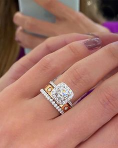 a woman's hand with two rings on her fingers and one ring in the middle