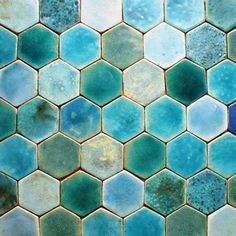 a blue and green tiled floor with hexagonal tiles on the bottom, in different colors