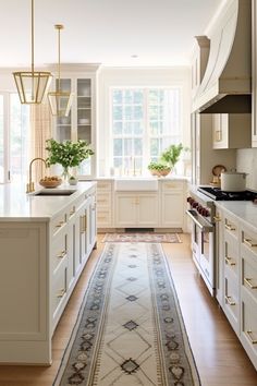 a large kitchen with white cabinets and an area rug on the floor in front of the stove