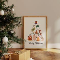 a christmas tree with presents under it in front of a white wall and wooden floor