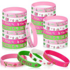 four bracelets with different designs on them, one is pink and the other is green