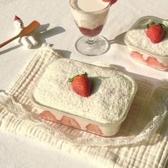 two desserts with strawberries are on a table