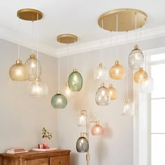 a bunch of lights hanging from the ceiling in a room with a dresser and window