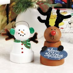 two snowmen are standing next to each other in front of a christmas tree and an ornament