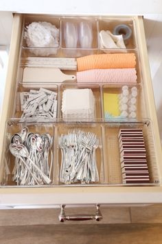 an organized drawer is shown with many different items in the drawers, including scissors and other things