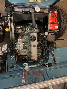 the engine and parts of a jeep are shown in this image, with wires attached to it