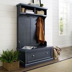 an entryway with a bench, coat rack and potted plant on the floor