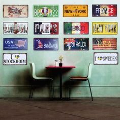 two chairs sitting at a table in front of a wall with license plates on it