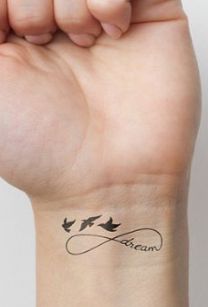 a woman's wrist tattoo with birds and the word love written on her arm