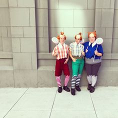 three women dressed in costumes standing next to each other