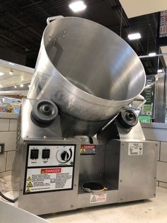 a large metal bowl sitting on top of a machine in a room filled with appliances