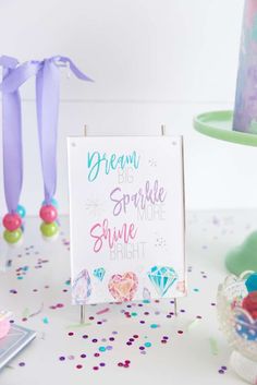 there is a sign that says dream big sparkle smile bright next to confetti