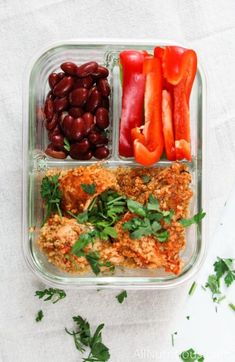 a plastic container filled with meat, beans and veggies on top of a table