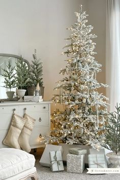 a white christmas tree with presents under it