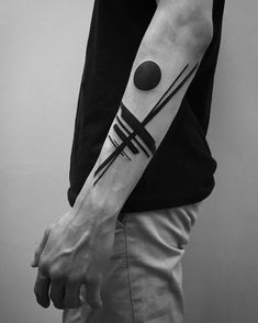 a black and white photo of a man's arm with a geometric tattoo on it