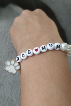 a person's arm with a bracelet that says dog mom and paw prints on it