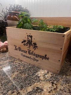 a wooden box with plants in it sitting on a counter