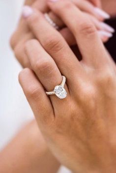 a woman's hand with a diamond ring on her finger and an engagement band