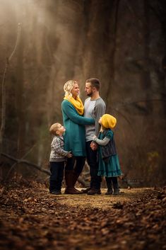 a family standing in the woods with their arms around each other and looking into the distance