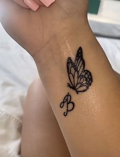 a woman's arm with a butterfly and musical notes tattoo on the left wrist