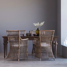 a dining room table with chairs and a vase on it