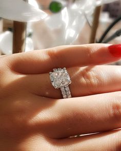 a woman's hand with a diamond ring on it