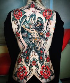 the back of a woman's body with tattoos on it