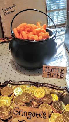 a pot full of gold coins sitting on top of a table next to a sign