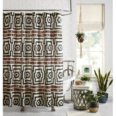 a bathroom with a shower curtain and potted plants on the floor next to it