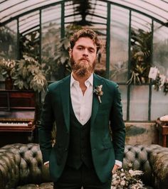 a man with a beard wearing a green suit