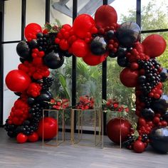 the balloon arch is decorated with red, black and silver balloons