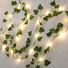 ivy vines with led lights on them are hanging from the side of a white wall