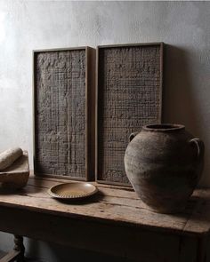 two vases sitting on top of a wooden table next to a plate and bowl