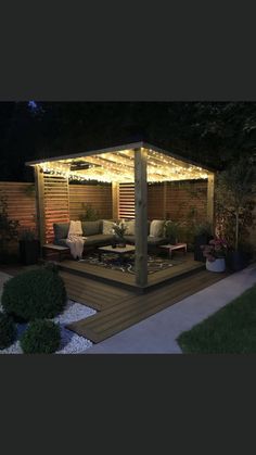 an outdoor living area is lit up at night with string lights on the pergolated roof