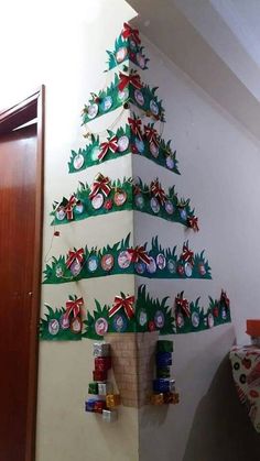 a christmas tree made out of toilet paper and other items on the wall next to it