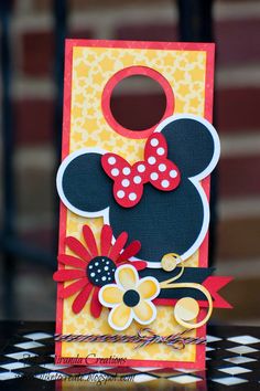 a close up of a mickey mouse card on a table with a chair in the background