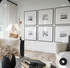 a living room filled with furniture and framed pictures on the wall above a coffee table